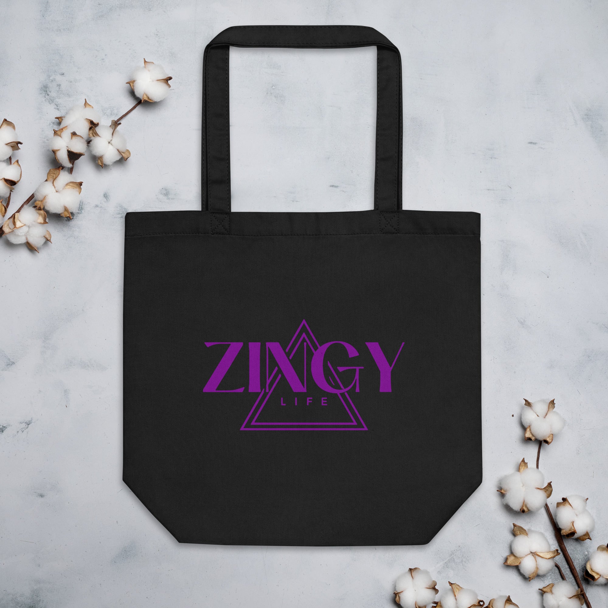 black organic cotton tote bag with the 'ZINGY' brand logo in purple text on the front.